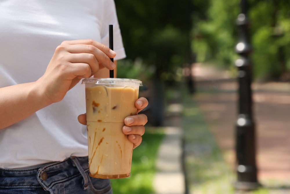 Woman,Holding,Takeaway,Plastic,Cup,With,Cold,Coffee,Drink,Outdoors, Cannucce eco per take-away